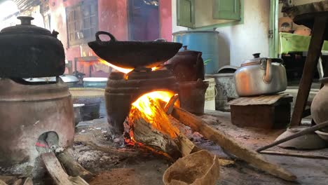 primer plano de una estufa tradicional y un fuego ardiente en el proceso de cocinar comida frita