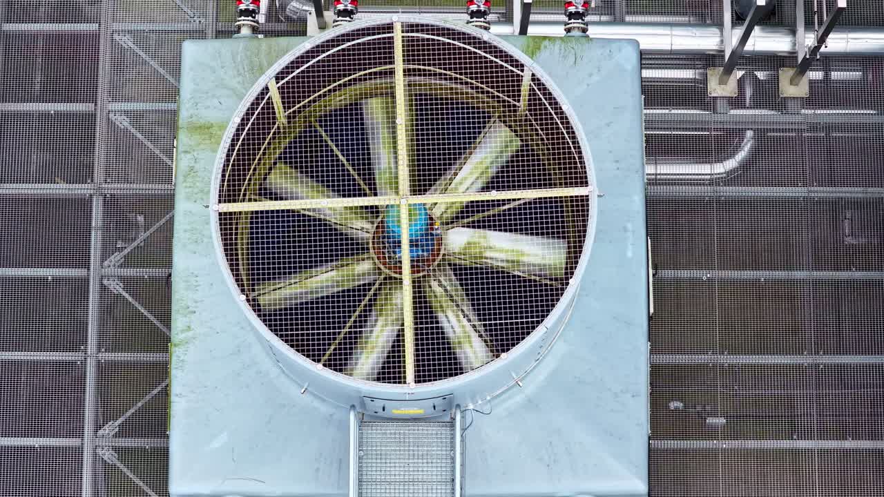 Industrial cooling fan operating on a rooftop for climate control, aerial top down view