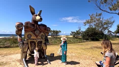 people interacting with kangaroo sculpture outdoors