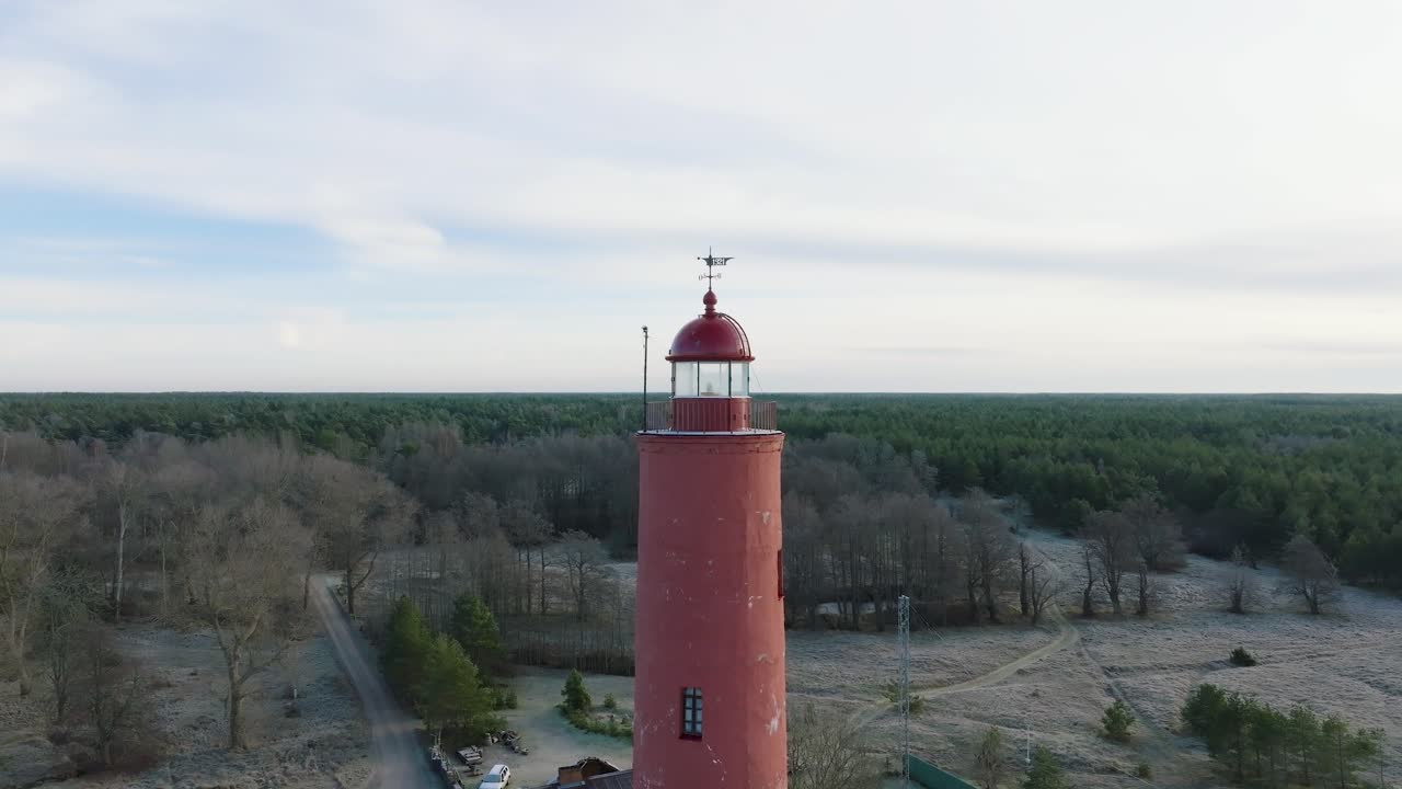 붉은 색 아크멘라그스 등대, 발트해 해안선, 라트비아, 하얀 모래 해변, 잔잔한 바다, 구름이 있는 화창한 날, 넓은 드론 샷이 뒤로 움직이는 공중 설정