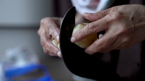 skilled working hands using traditional indian aruvamanai slicing potato close-up