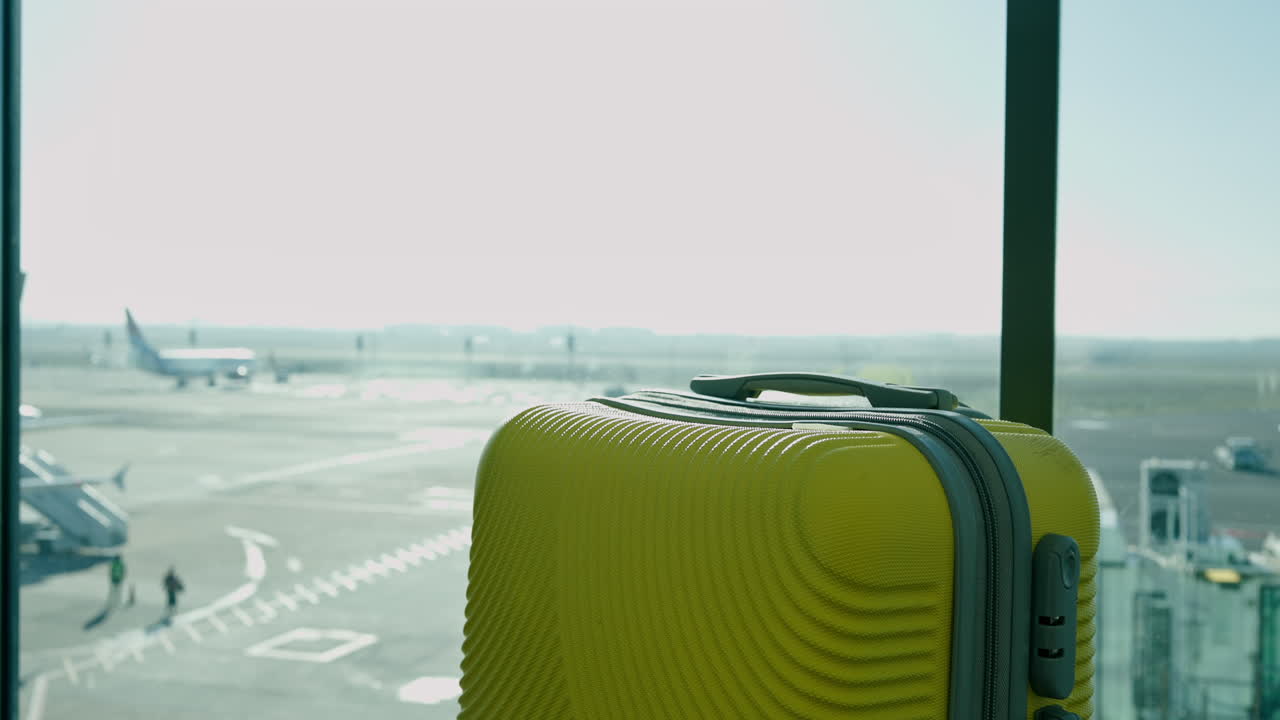 Suitcase in airport terminal with airplane in background