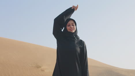 Bella-Mujer-Musulmana-Con-Vestido-Negro-Tradicional-Y-Hiyab-Posando-En-El-Desierto