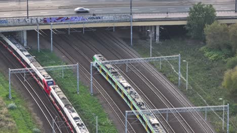 Following-drone-shot-of-a-train-with-traffic-bridge