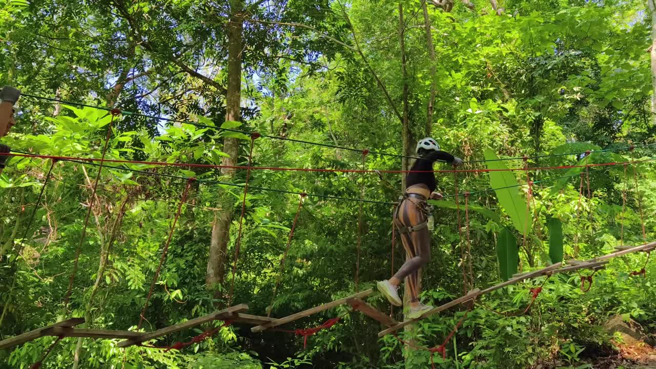 People having fun on a treetop adventure course in a jungle environment