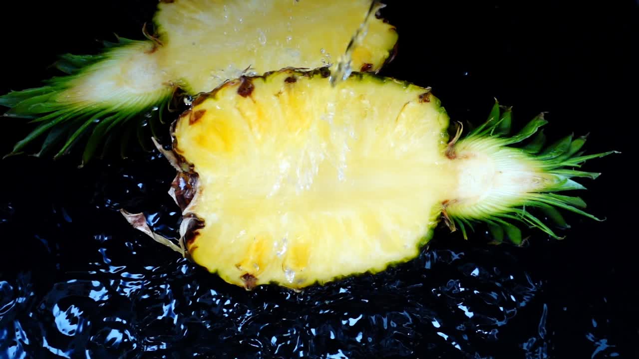 The stream of water flows on pineapple. Slow motion