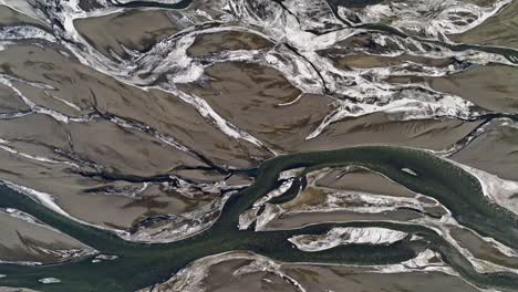 Snow-and-river-pattern-in-Landeyjahöfn,-Iceland,-aerial-top-down-view-in-Winter