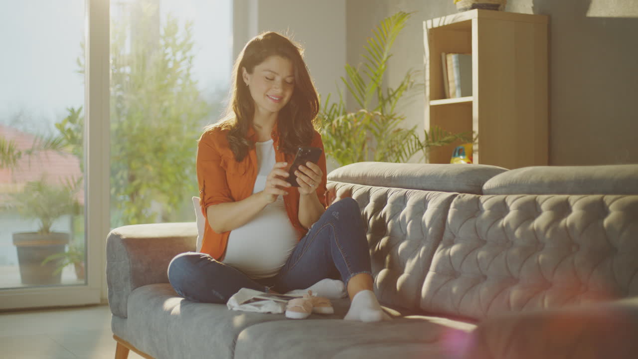 Pregnant Woman Using Mobile Phone at Home