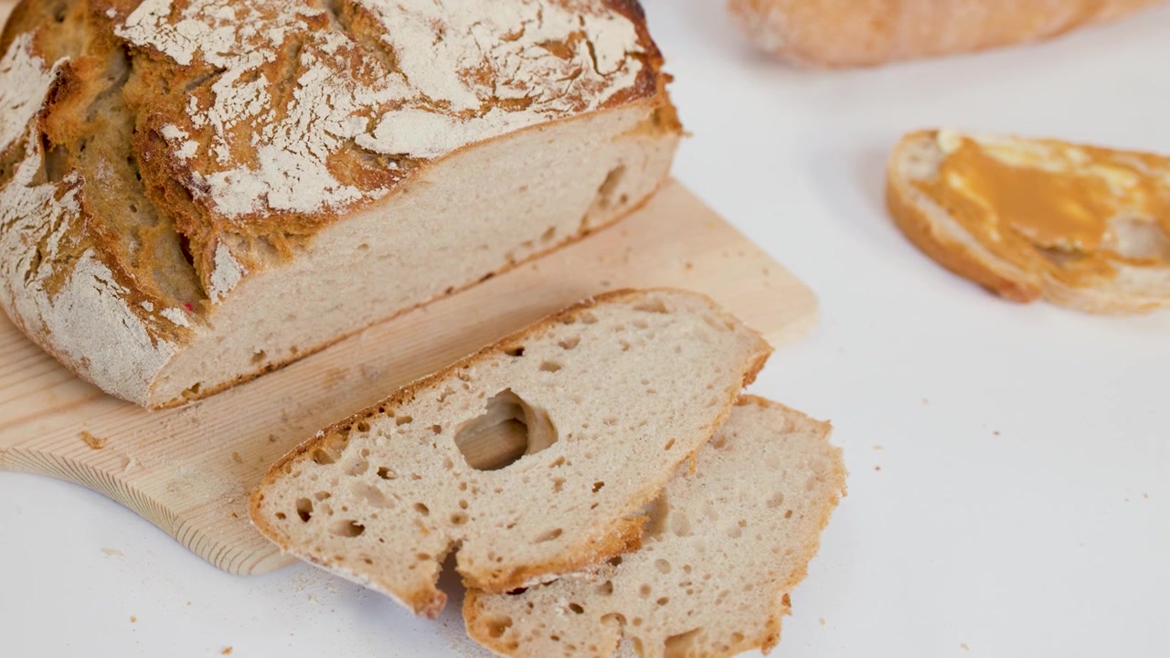 Hand Picking a Slice of Freshly Baked Sourdough Bread