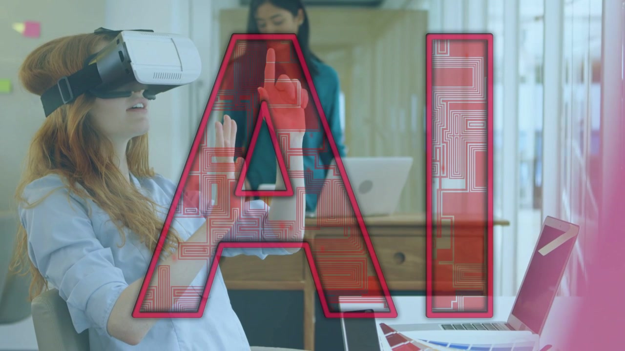 Seated woman wearing VR headset reaching office UI, testing red AI while peer working on laptop