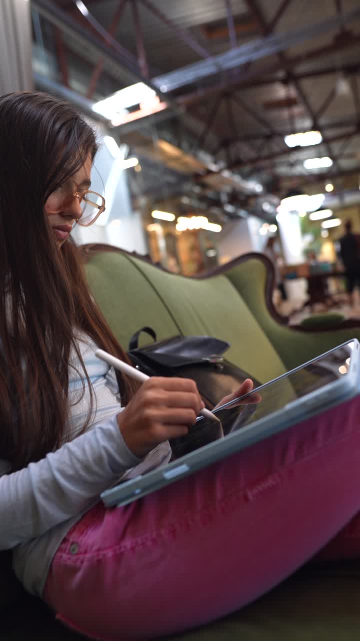 chica dibujando en una tableta en un café moderno