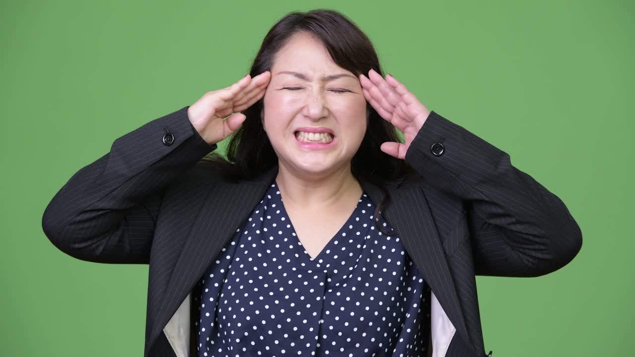 성숙하고 아름다운 아시아 사업가 여성이 두통을 고 있습니다.