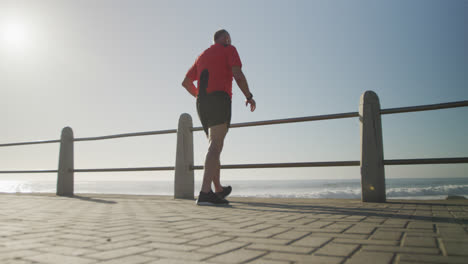 Senior-man-taking-a-break-from-running-on-the-promenade