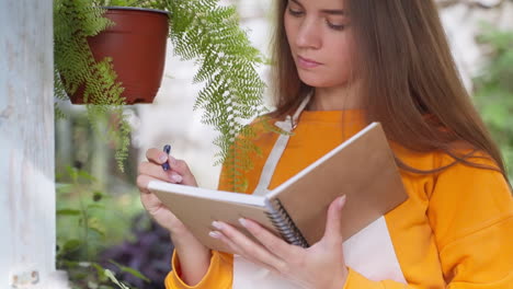 mujer tomando notas en un invernadero