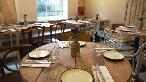 Empty-restaurant-with-set-tables-and-chairs,-tilt-shot