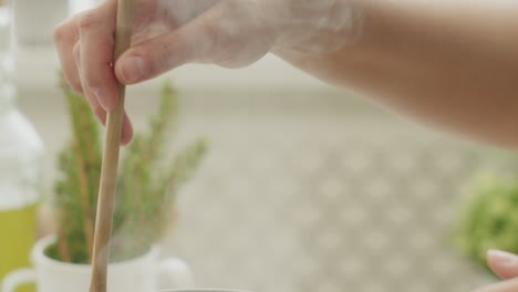 Woman-stirring-pasta-in-saucepan-on-stove