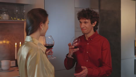 couple enjoys a romantic evening drinking red wine in a cozy home setting