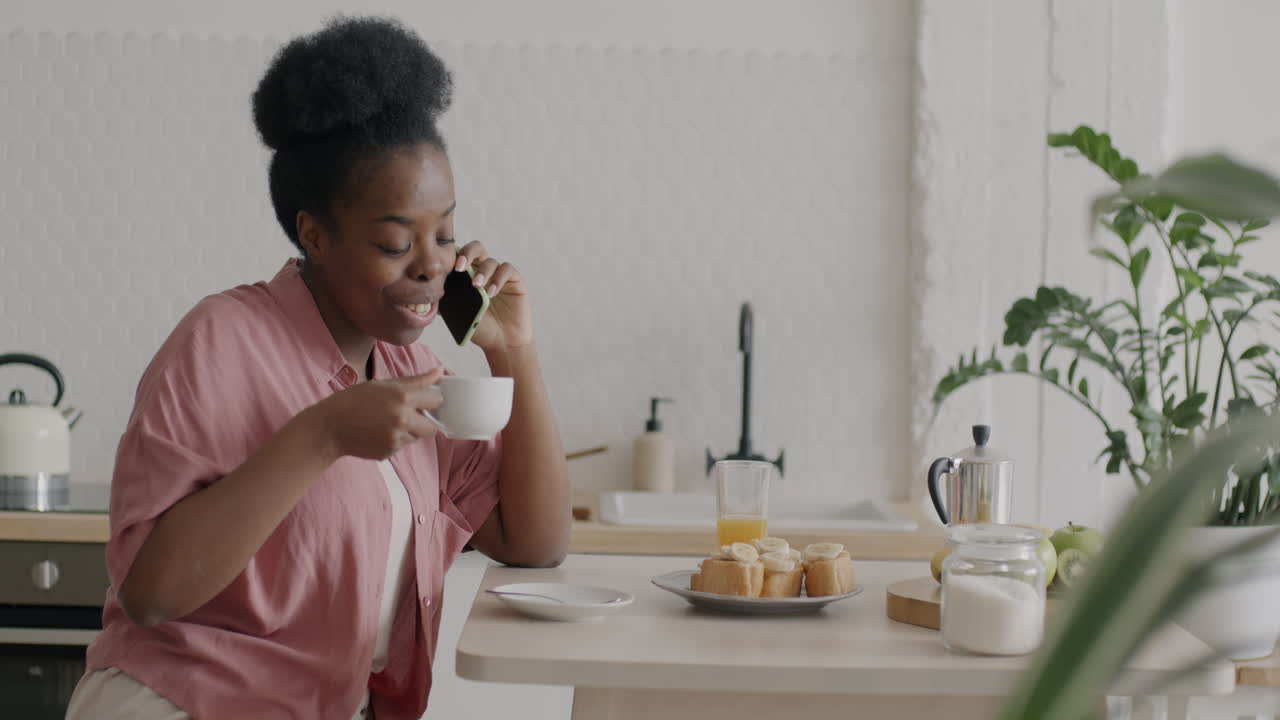 Woman having breakfast and making a phone call