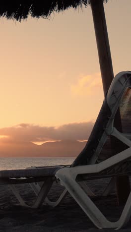 sunset beach scene with beach chairs