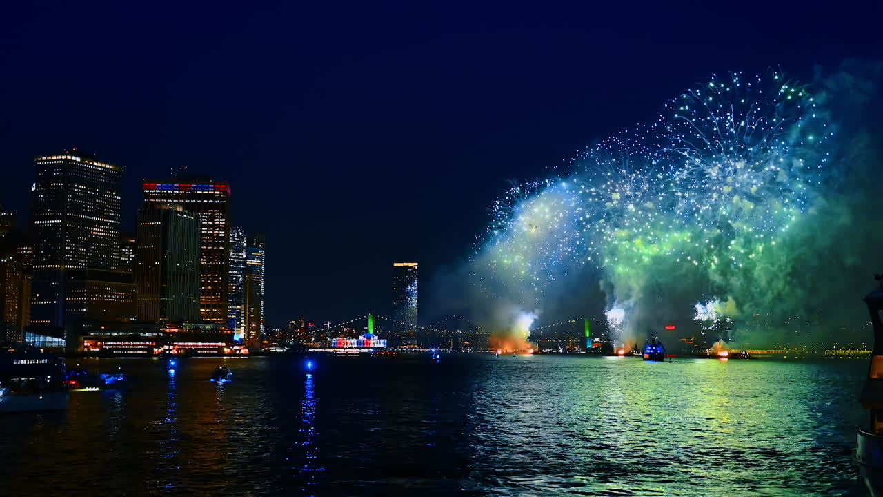 Fantastic fireworks reflect in the river and facades of the buildings. Amazing bright celebration in New York at night time