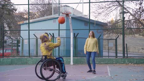 Behinderter-Junger-Mann-Im-Rollstuhl,-Der-Mit-Seiner-Freundin-Basketball-Spielt.