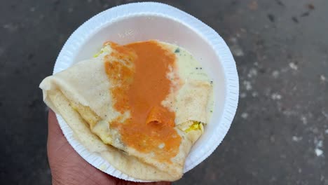 profile view of dosa with sambar chutney on top.
