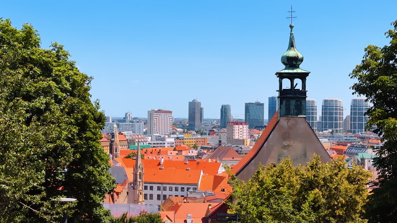 Bratislava summer skyline view. Overlooking Bratislava, red rooftops contrast with modern buildings under a clear blue sky in summer