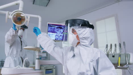 patient pov of dentist in ppe suit explaining teeth treatment