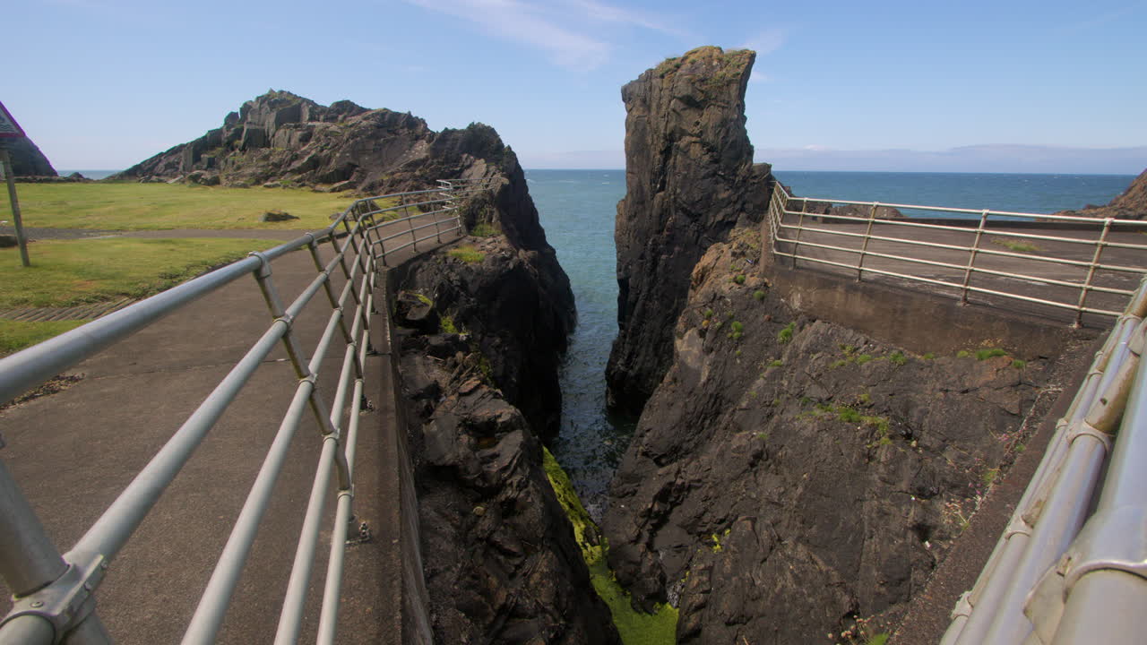 Extra wide shot looking at a rocky crevasse with the sea, at Dunskey Street carpark, Portpatrick