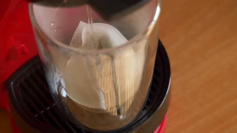 Verter-Agua-En-Un-Vaso-Transparente-Con-Bolsitas-De-Té