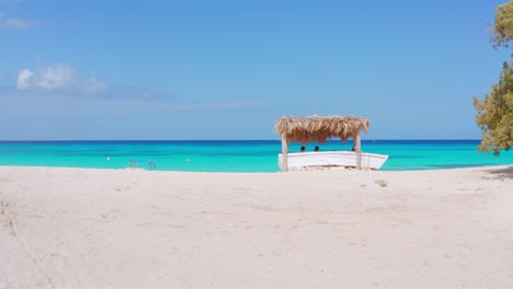 Tourists-sitting-under-seafront-gazebo-on-beach-at-Eco-del-Mar,-Pedernales