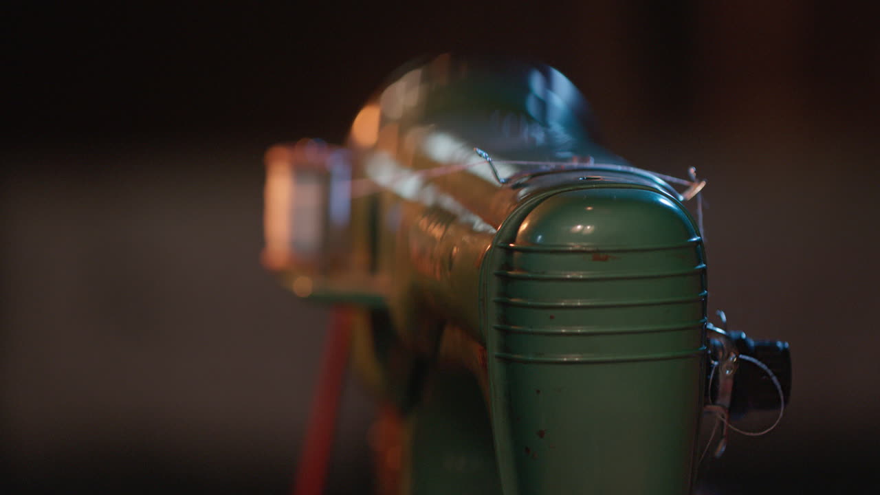 Vintage Green Film Projector Operating in a Dark Room
