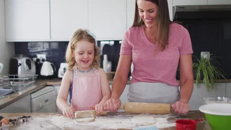 caucasian mother and daughter having fun cooking together