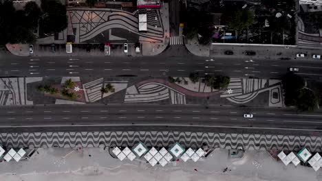 aerial top down sideways panning on copacabana empty beach and boulevard at first light early morning sunrise with a few cars passing