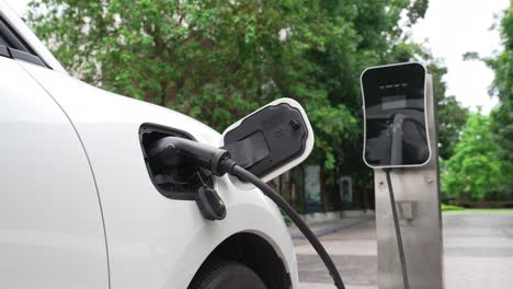 concepto de aparcamiento progresivo de automóviles eléctricos y recarga en la estación de carga.