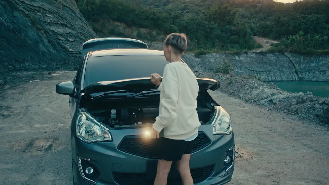 Woman dealing with a car breakdown on a rural road