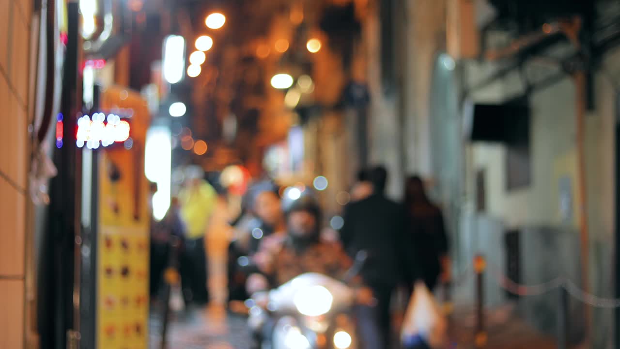 스쿠터와 자전거를 타고 있는 야간 교통, 도시 배경, 은 거리의 불명확한 불빛으로 색이 흐릿한 보케 배경