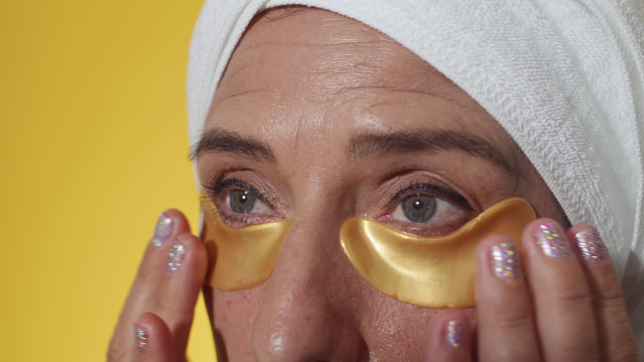 Mature Woman Applying Hydrogel Patches under Eyes