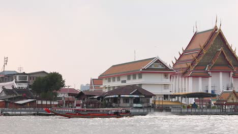 boat travels past temple on chao phraya river