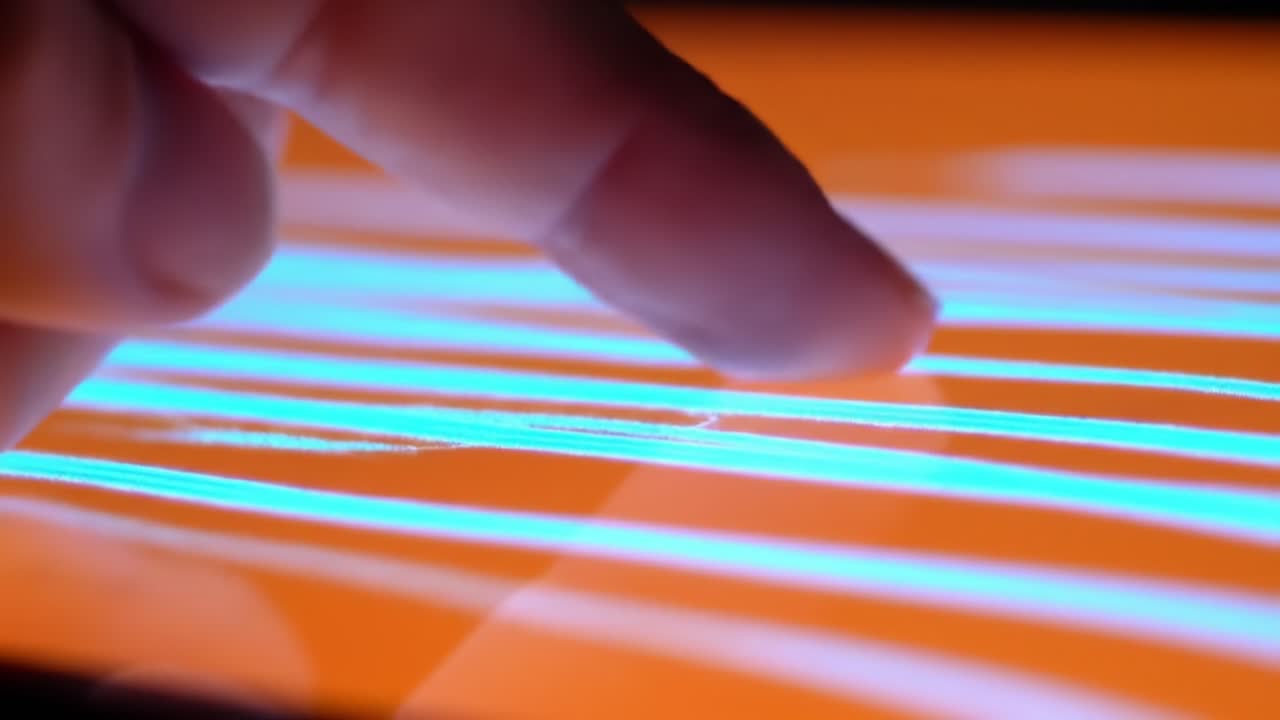 Exploring Digital Interactions: A Close-Up View of a Finger Gliding Over a Vibrant Touchscreen Display with Luminous Lines Pattern