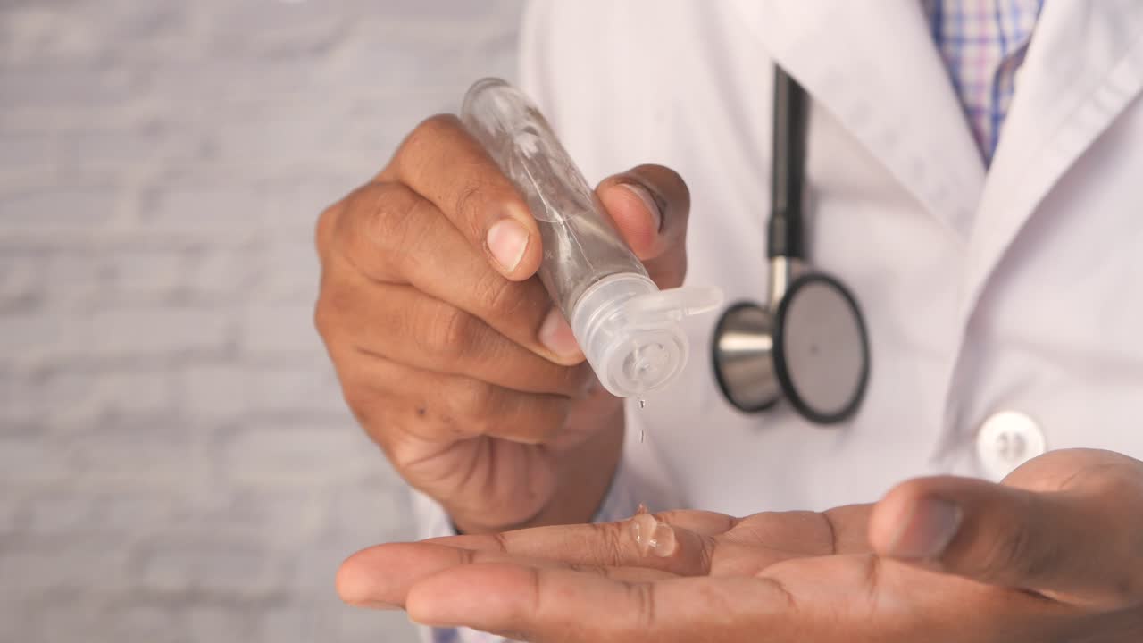 Dottore che usa il disinfettante per le mani: Igiene e Prevenzione