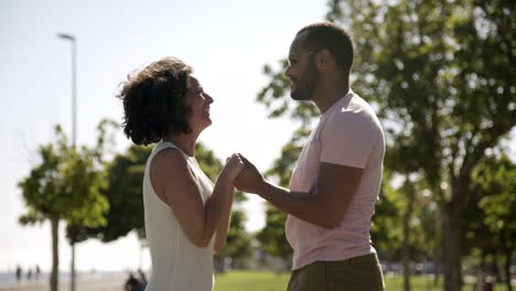 una feliz pareja multiétnica abrazándose en el parque