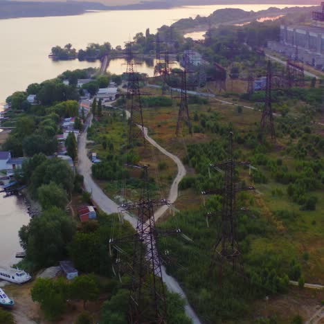 high-voltage power lines in nature. transmission towers near the river. electricity pylons tower at sunset. energy efficiency concept.