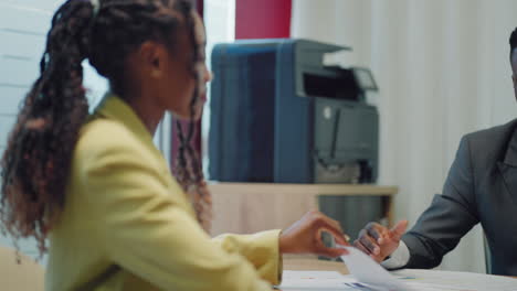 Making-a-first-impression.-Young-black-man-meets-potential-employer-in-office-for-interview.-Welcome-to-the-company.-Smiling-black-woman-sitting-at-office-desk-and-talking-to-during-job-interview