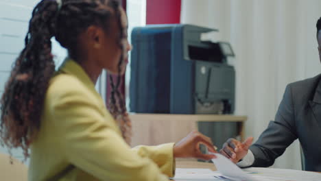 fazer uma primeira impressão. um jovem negro conhece um potencial empregador no escritório para uma entrevista. bem-vindo à empresa. uma mulher negra sorridente sentada na mesa do escritório e falando durante uma entrevista de emprego