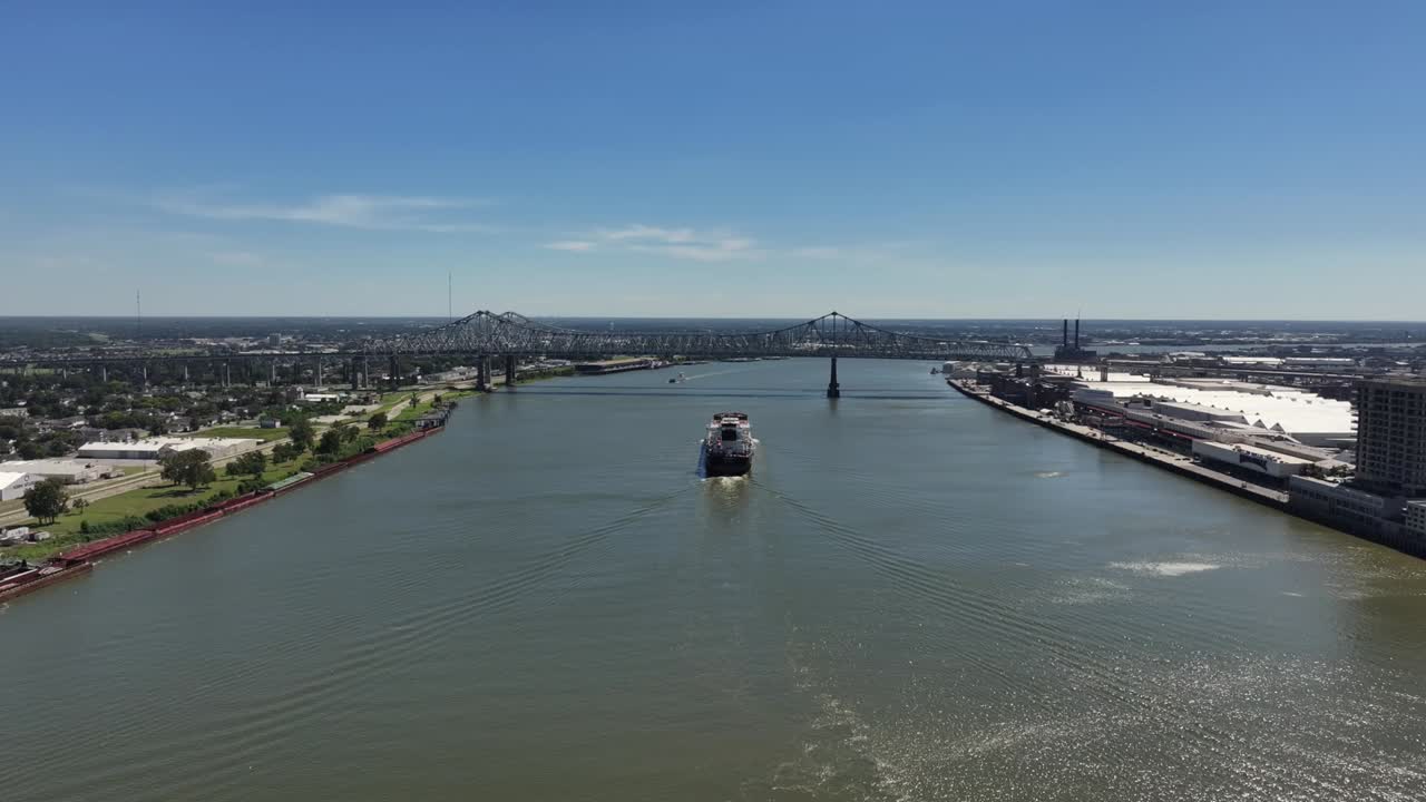 Aerial View of a Cargo Ship Passing Under a Bridge on a River