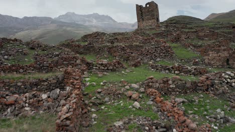 ancient stone ruins with dilapidated tower on mountainous terrain