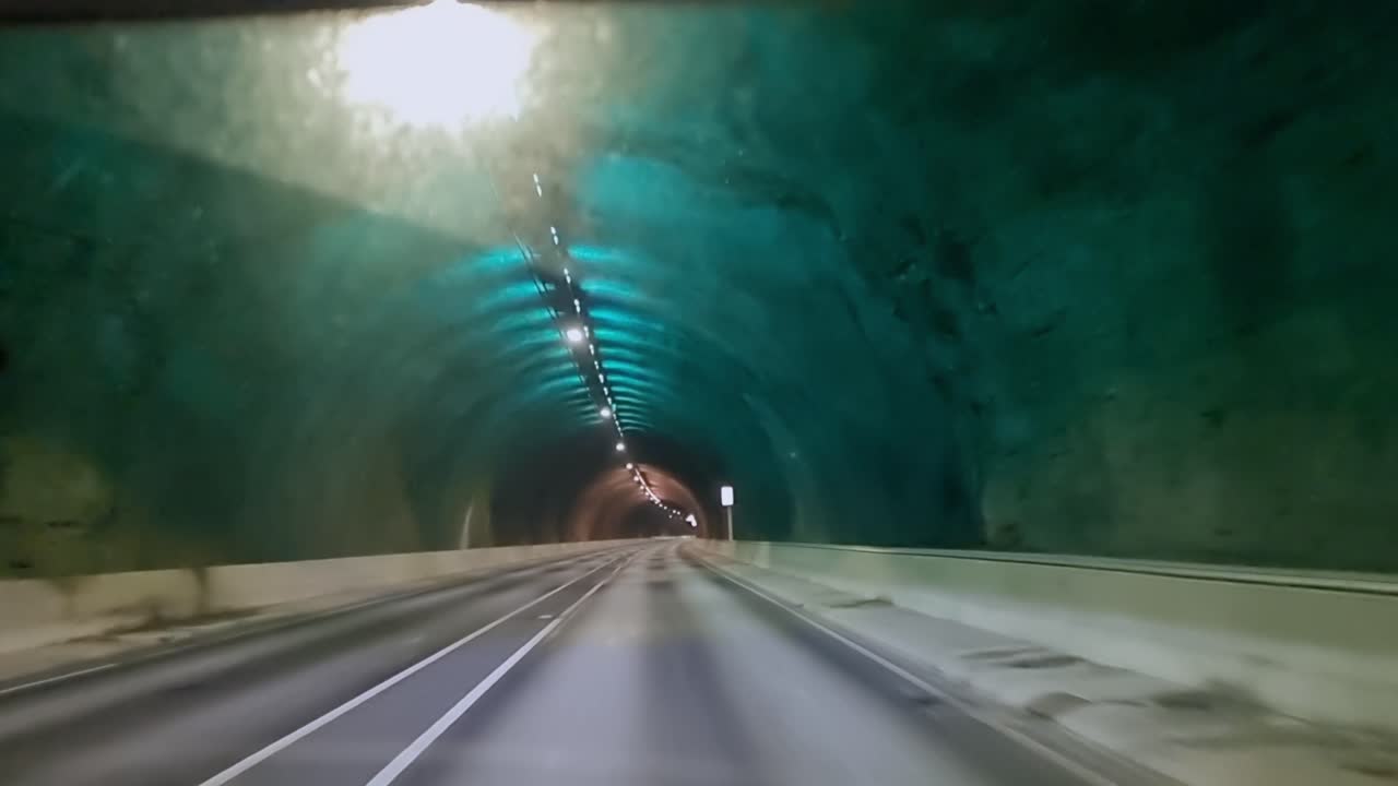 Punto di vista di guida all'interno del moderno Eysturoyartunnilin, un grande tunnel stradale sottomarino nelle Isole Fær Øer con un'illuminazione unica.