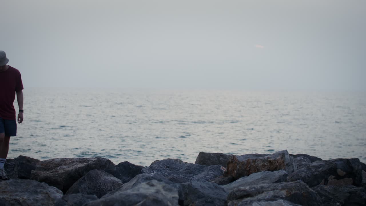 해가 지는 동안 해변을 고 있는 부부