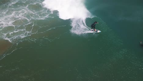 Professional-Surfer-catching-a-long-wave-in-South-America,-Peru---Drone-Aerial-Tracking-Shot
